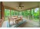 Relaxing screened patio with dining table, bench seating, ceiling fan, and views of mature trees at 2004 Viscount Dr, Matthews, NC 28104