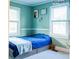 Charming bedroom featuring blue bedding, natural light from two windows, and cactus decor at 24007 Old Aquadale Rd, Albemarle, NC 28001