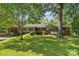 Quaint brick home nestled among lush trees and a well-maintained lawn at 2500 Kendrick Dr, Charlotte, NC 28214