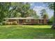 Charming one-story brick home with manicured lawn and mature trees, providing a serene curb appeal at 2500 Kendrick Dr, Charlotte, NC 28214