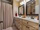 Bathroom with a double sink vanity, large mirrors, decorative accents, and a shower with beige curtain at 2590 Berne Ln, Sherrills Ford, NC 28673
