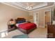 Serene bedroom featuring a tray ceiling, ceiling fan, and a glimpse into the adjoining bathroom at 2590 Berne Ln, Sherrills Ford, NC 28673