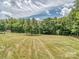Expansive backyard featuring lush greenery, mature trees, and ample space for outdoor activities at 314 Candella Dr, Matthews, NC 28104