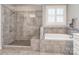Bathroom with tiled shower, soaking tub, tiled floors, and a window with shutters at 314 Candella Dr, Matthews, NC 28104