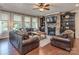 Cozy living room with stone fireplace, built-in shelving, hardwood floors, and lots of natural light at 314 Candella Dr, Matthews, NC 28104
