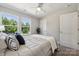 Bright bedroom featuring two windows, a ceiling fan, and neutral decor at 384 Speedway Pl, Concord, NC 28027