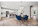 Bright dining area showcases blue chairs surrounding a glass table, adjacent to a modern kitchen at 384 Speedway Pl, Concord, NC 28027