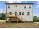 Back exterior view showcasing the deck, white siding, and stairs leading to the yard at 384 Speedway Pl, Concord, NC 28027