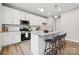 Modern kitchen features a breakfast bar, stainless steel appliances, and granite countertops at 384 Speedway Pl, Concord, NC 28027