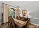 Formal dining room featuring a large window, elegant chandelier, and a spacious table with seating at 4025 Cherrybrook Dr, Mint Hill, NC 28227