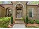Inviting front entrance with a brick facade, arched doorway, and well-maintained landscaping at 4025 Cherrybrook Dr, Mint Hill, NC 28227