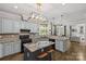 This open kitchen features granite countertops, stainless steel appliances, light blue cabinets, and an island with bar seating at 4025 Cherrybrook Dr, Mint Hill, NC 28227