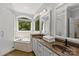 The luxurious main bathroom is equipped with double sinks, a separate shower, and a soaking tub with garden views at 4025 Cherrybrook Dr, Mint Hill, NC 28227