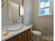 Modern half bathroom featuring an elongated sink, vanity with a wood design, and natural light at 4121 Selwyn Walk Ct, Charlotte, NC 28209