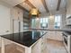 Modern kitchen features stainless appliances, black counters, a center island, and a beautiful hanging light fixture at 4121 Selwyn Walk Ct, Charlotte, NC 28209