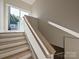 Bright staircase featuring natural wood treads and white risers and railings, leading to a sunny landing at 4121 Selwyn Walk Ct, Charlotte, NC 28209