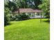 Backyard view showing a lush green lawn with mature trees surrounding the property at 423 Tot Dellinger Rd, Cherryville, NC 28021