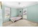 Bedroom featuring neutral carpet, pale green walls, and a floral-patterned bed at 4321 Timberwood Dr, Gastonia, NC 28056