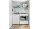 Well-lit laundry room with front-loading washer and dryer, wire shelving, and light tile flooring at 4321 Timberwood Dr, Gastonia, NC 28056