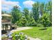 Landscaped backyard featuring a well-maintained lawn, mature trees, and a patio area at 4386 Oldstone Dr, Harrisburg, NC 28075