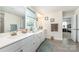 Bright bathroom featuring dual sinks, modern fixtures, tile floors, and a view to a bedroom at 4386 Oldstone Dr, Harrisburg, NC 28075