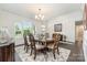 Bright dining room features hardwood floors, six-seat table and chairs, and large windows at 4386 Oldstone Dr, Harrisburg, NC 28075