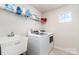 Functional laundry room featuring a utility sink, washer, dryer, and shelving at 4386 Oldstone Dr, Harrisburg, NC 28075