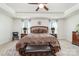 Relaxing main bedroom featuring a tray ceiling, ceiling fan, and a cozy sitting area at 4386 Oldstone Dr, Harrisburg, NC 28075