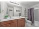 Bathroom with double sinks, shower and dark wood cabinets at 5009 Granite Creek Ln, Charlotte, NC 28269
