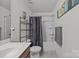 Bathroom with white tile flooring, shower and dark wood cabinets at 5009 Granite Creek Ln, Charlotte, NC 28269