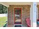 Inviting front porch with a stylish stone facade, leading to a cozy entrance and a pop of color from outdoor seating at 5009 Granite Creek Ln, Charlotte, NC 28269