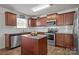 Well-lit kitchen boasts stainless steel appliances, granite countertops, and wood cabinets at 5009 Granite Creek Ln, Charlotte, NC 28269