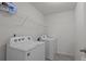 Well lit laundry room with washer, dryer and white wire shelving above at 5009 Granite Creek Ln, Charlotte, NC 28269