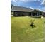 Expansive backyard featuring lush green grass, a cozy screened porch, and a stone patio at 5332 Pembrey Dr, Denver, NC 28037