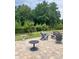 Scenic backyard view with a stone patio, fire pit, and mature trees at 5332 Pembrey Dr, Denver, NC 28037