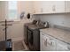 Functional laundry room featuring modern appliances, granite countertops, and white cabinetry at 5332 Pembrey Dr, Denver, NC 28037
