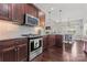 Stylish kitchen with stainless steel appliances, custom cabinets, and a view to the living area at 5379 Roberta Meadows Ct, Concord, NC 28027