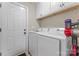 Bright laundry room featuring a front loading washer and dryer and cabinets for storage at 5379 Roberta Meadows Ct, Concord, NC 28027