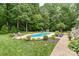 Inviting backyard featuring an in-ground pool with manicured landscaping, patio and a storage shed at 6006 Casswell Cir, Matthews, NC 28104