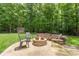 Beautiful backyard with a fire pit, stone patio, lush lawn, landscaping and a storage shed at 6006 Casswell Cir, Matthews, NC 28104