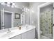 Bright bathroom featuring a double vanity, framed mirror and separate shower with patterned curtain at 6006 Casswell Cir, Matthews, NC 28104