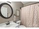 Charming bathroom features an oval mirror, elegant faucet, toilet and patterned shower curtain at 6006 Casswell Cir, Matthews, NC 28104