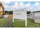 Sign indicating future commercial development with lush greenery and construction equipment at 6006 Casswell Cir, Matthews, NC 28104