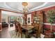 Elegant dining room with a chandelier, rich red walls, and a view into the adjacent living area at 6006 Casswell Cir, Matthews, NC 28104