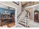 Inviting foyer with a staircase and view into a home office, showcasing hardwood floors and natural light at 6006 Casswell Cir, Matthews, NC 28104