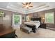 Spacious main bedroom suite features a tray ceiling, fan, and balcony access for outdoor enjoyment at 6006 Casswell Cir, Matthews, NC 28104