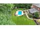 Aerial view of a backyard with a beautiful kidney-shaped pool, patio, lush landscaping, and adjacent screened in porch at 6006 Casswell Cir, Matthews, NC 28104