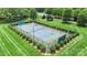 Aerial view of a community tennis court surrounded by manicured landscaping and lush green space at 6006 Casswell Cir, Matthews, NC 28104