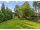 Lush backyard with manicured lawn, mature trees, and privacy hedges, perfect for outdoor enjoyment at 6242 Creola Rd, Charlotte, NC 28270