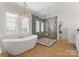 Luxurious bathroom featuring a freestanding tub, glass-enclosed shower, and seamless access to the walk-in closet at 6242 Creola Rd, Charlotte, NC 28270